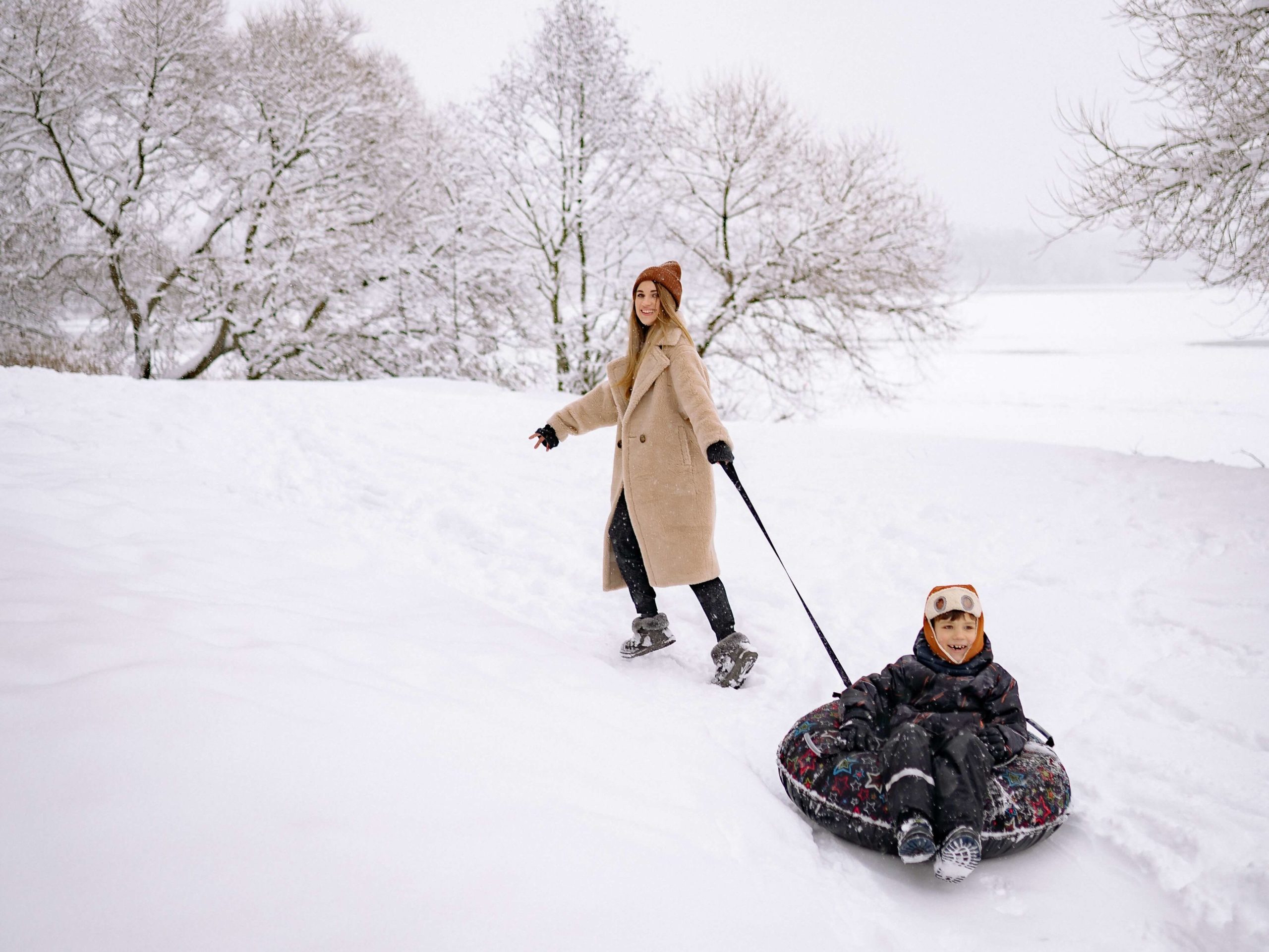 Mère et enfant glisse dans la neige pour les congés de la relâche scolaire.